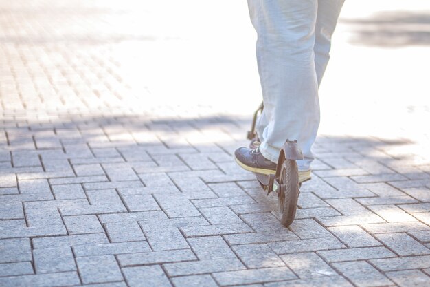 Eco vriendelijke transport electro scooter op stadsstoep tegel in zonnige dag