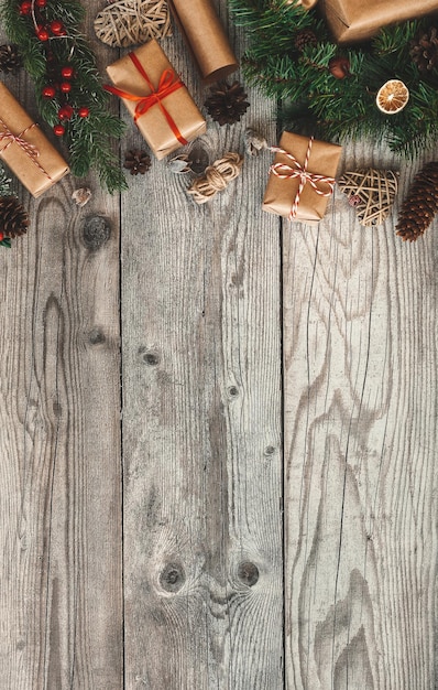 Eco-vriendelijke zelfgemaakte nieuwjaarsdecoratie. Geen afval kerst plat lag met geschenken op een rustieke houten achtergrond. Dozen van herbruikbaar duurzaam gerecycled papier.