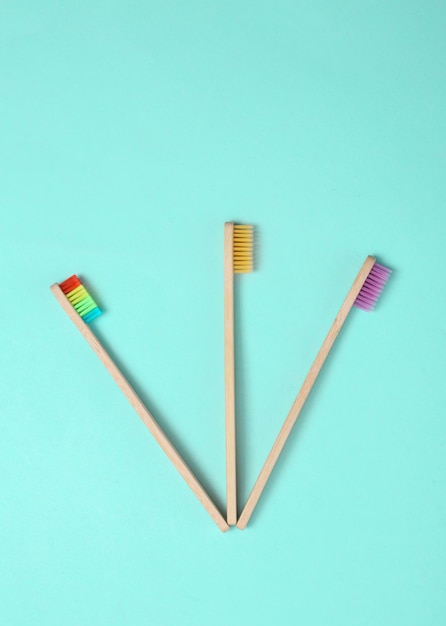 Ecofriendly bamboo toothbrushes on blue background Top view