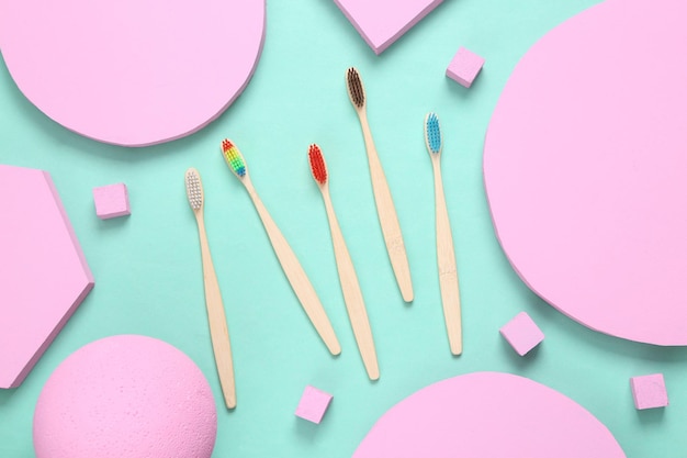 Ecofriendly bamboo toothbrushes with pink different geometric shapes on blue background Minimalism Creative layout