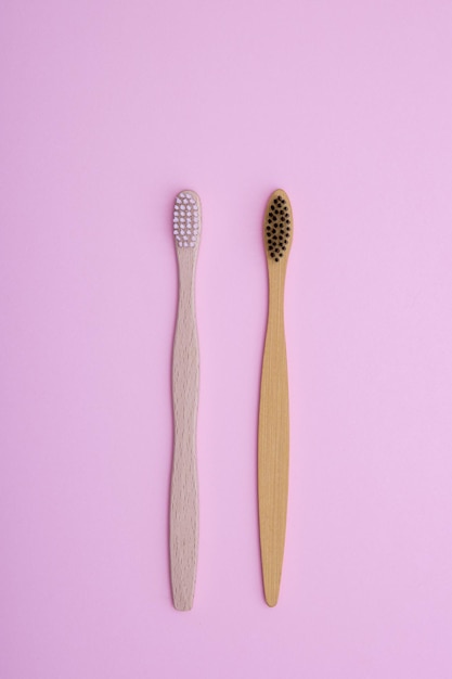 Ecofriendly bamboo wooden toothbrushes on a pink background The concept of caring for the environment the rejection of plastic and zero waste Copy space minimalism