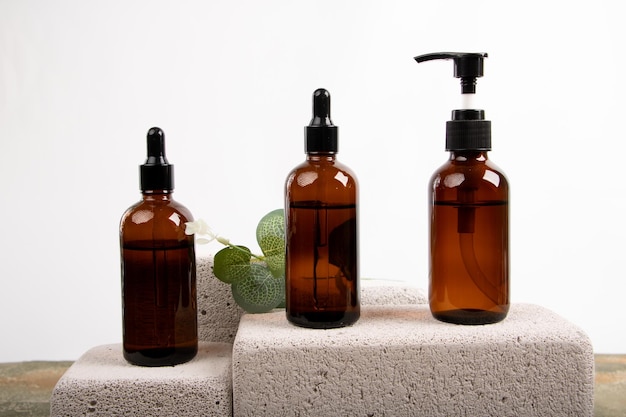 ecofriendly beauty bottles with pump and dropper on stone block background