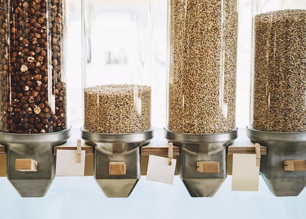 Ecofriendly zero waste shop dispensers for cereals nuts and\
grains in sustainable plastic free grocery store bio organic food\
shopping at small local businesses new trend alternative\
buying