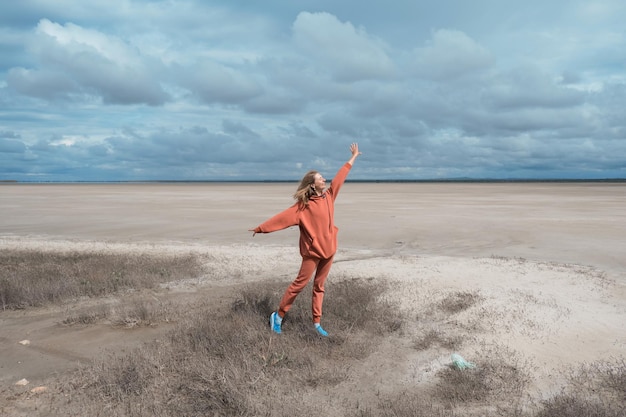 Ecological catastrophe in Israel, in the Middle East, the disappearance of the Dead Sea. shallowing, reduction. dried and, no greenery. A girl in an orange suit in a jump