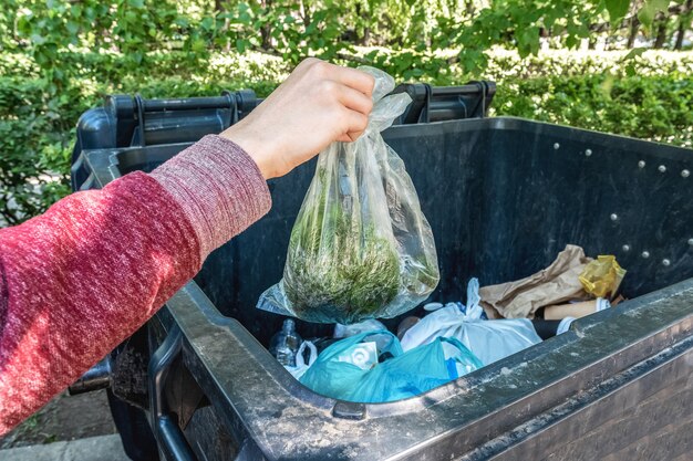 Ecology and environmental protection A man throws garbage into a dumpster