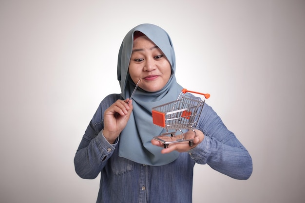 Ecommerce Concept Muslim Lady Holding Mini Trolley and Credit Card