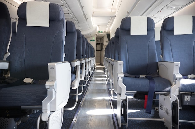 An economy class empty clean cabin of the airplane empty dark blue chairs