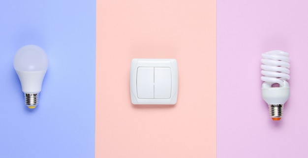 Economy light bulbs, the switch on the pastel background. Top view. Minimalism electro consumer concept