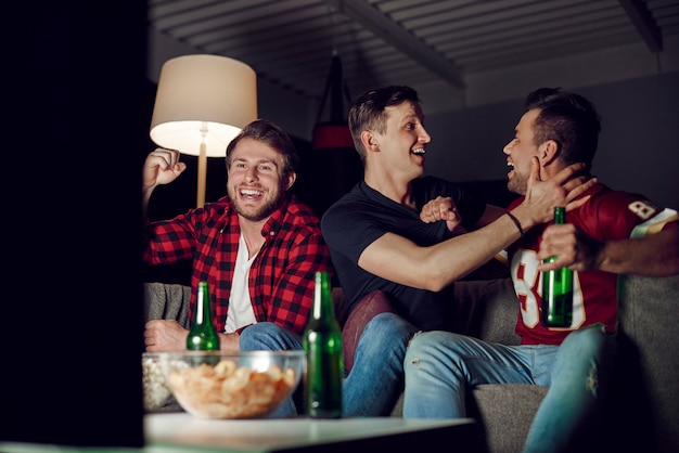 Ecstatic football fans cheering at home