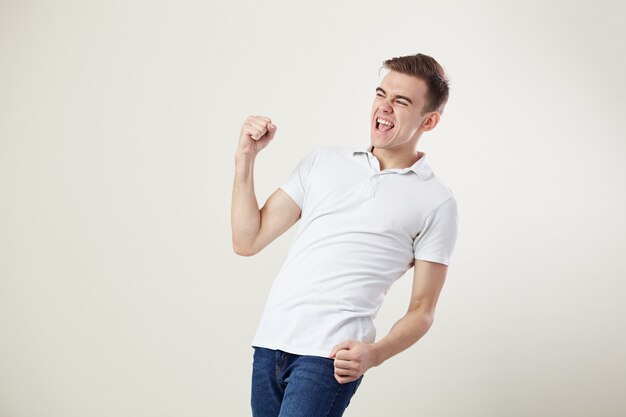 Ecstatic full of energy guy  shouts in the studio on a white background .