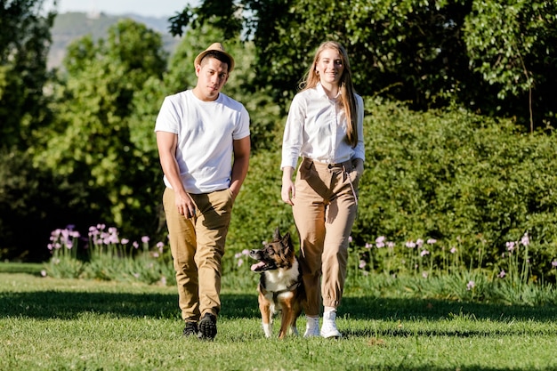 Ecuadoriaanse man en blanke vrouw die hun hond in het park wandelen. Jong modern paar