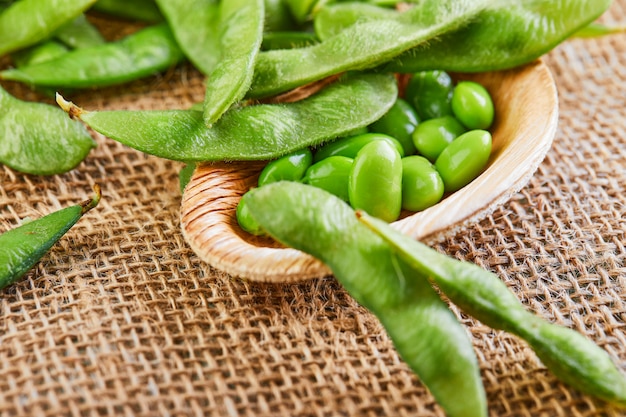 Edamame or soybeans in a wooden plate on a sackcloth