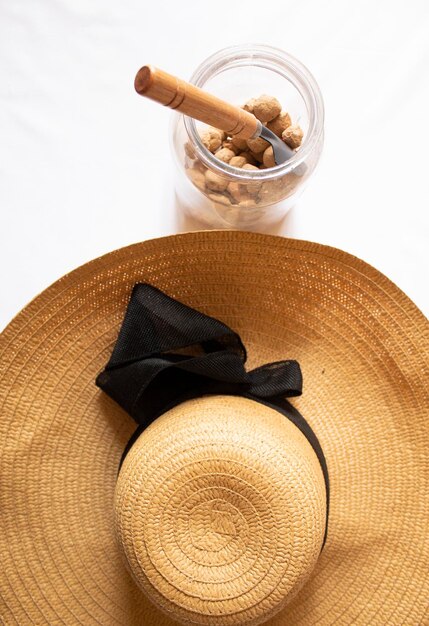 사진 흰색 배경에 유리병과 여름 모자에 있는 식용 캐러멜 점토 돌