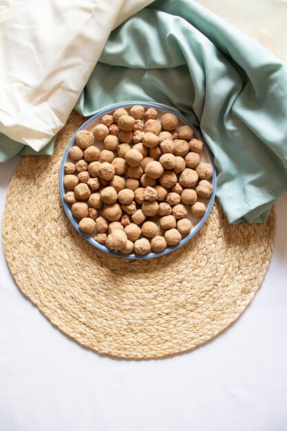 Edible caramel clay stones in a round plate on a white background