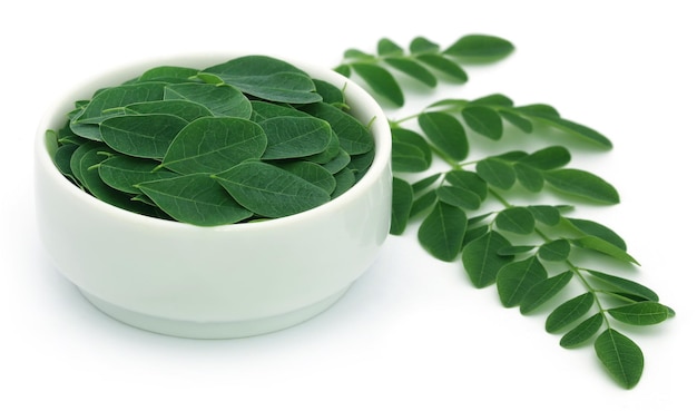 Photo edible moringa leaves over white background