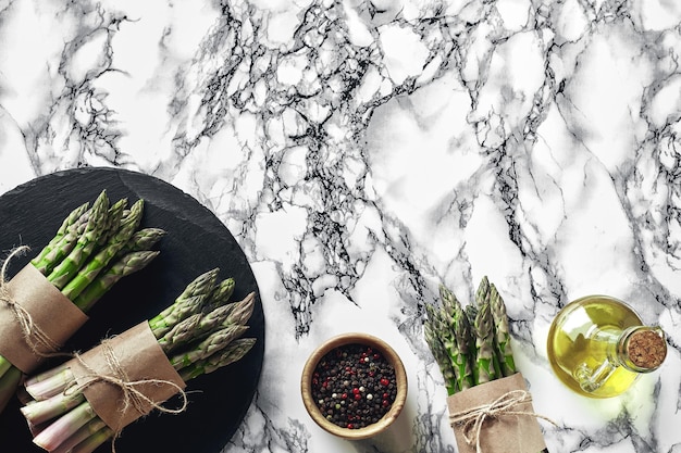 An edible raw stems of asparagus on a marble background