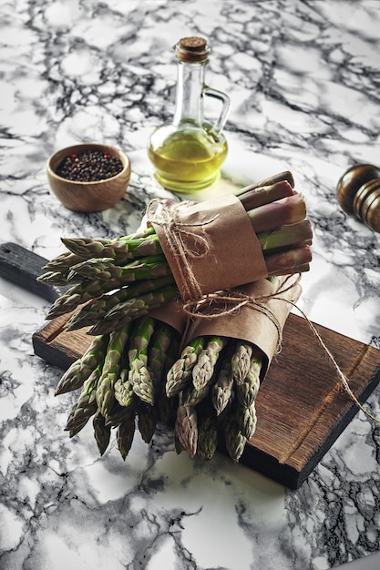 An edible raw stems of asparagus on a marble background