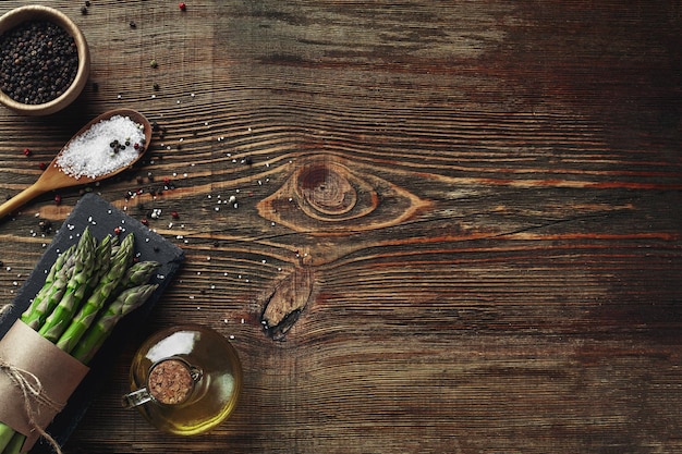 An edible raw stems of asparagus on a wooden background