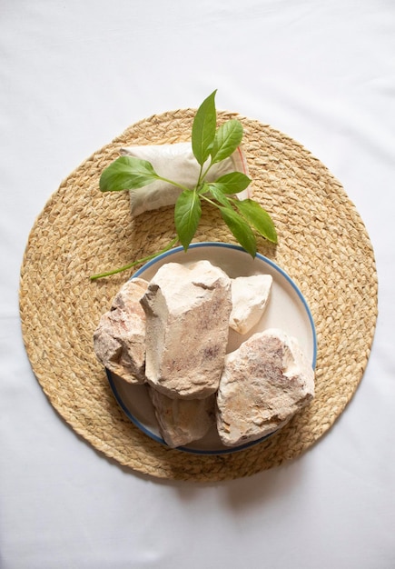 Edible white clay stones with small green leaves minimal flat lay