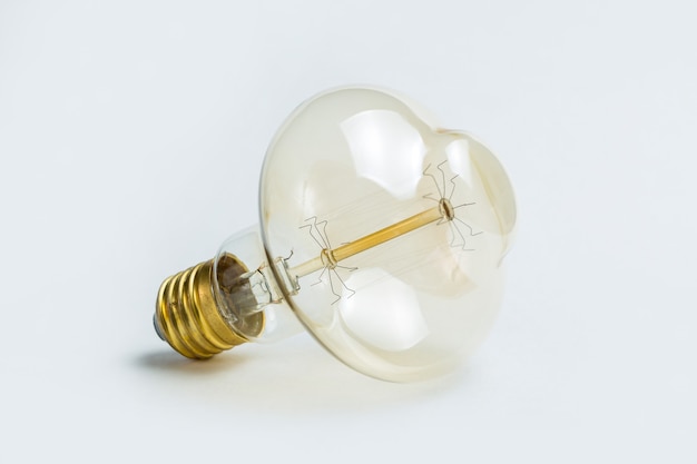 Edison bulb on white background. Vintage light bulb with golden base.