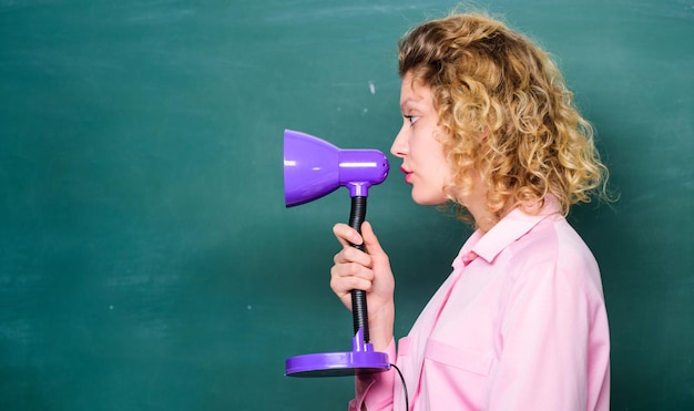 Educatief idee Vrouwenwerk aan helder glanzend idee Creativiteit en inspiratie Verlicht proces van studeren Kennisdag Leraar houdt tafellamp in de hand schoolbordachtergrond Inzicht en idee