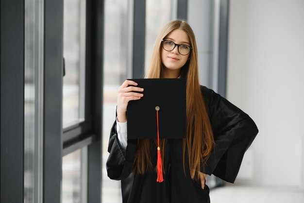 Educatief thema: afstuderend studentmeisje in een academische jurk.