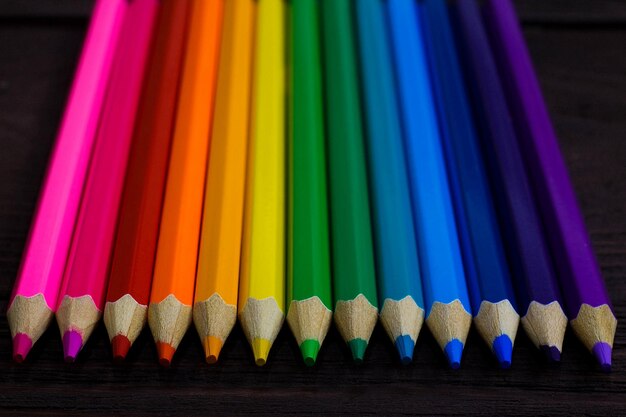 Фото Концепция образования и творчества цветные карандаши на деревянном фоне