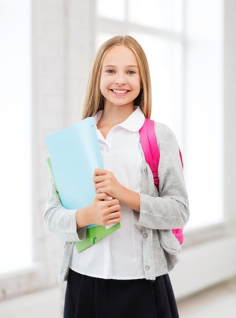 Фото Концепция образования и школы - счастливая и улыбающаяся девочка-подросток