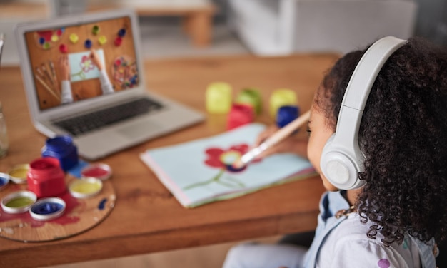 Foto educazione artistica e online con una ragazza elearning o studio online con un laptop e internet da studente creatività al computer e tutorial con una bambina che guarda un video per studiare