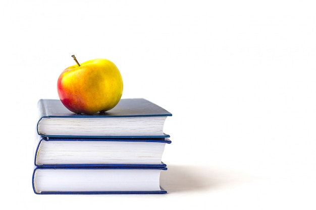 Education or back to school . An appleon a stack of books isolated on a white  with copyspace. 