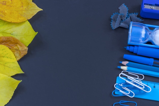 Istruzione o ritorno a scuola. rifornimenti di scuola blu sulla lavagna con copyspace.