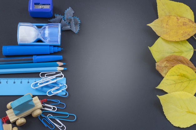 Foto istruzione o ritorno a scuola. rifornimenti di scuola blu sulla lavagna con copyspace.