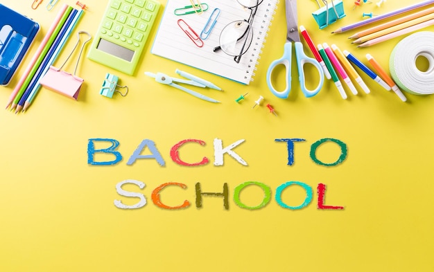 Photo education or back to school concept top view of colorful school supplies with books color pencils calculator pen cutter clips and apple on pastel paper background