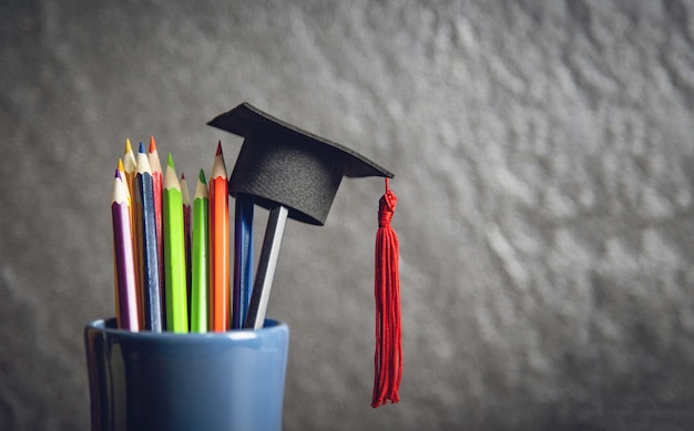 Education and back to school concept with graduation cap on pencils colour in a pencil case