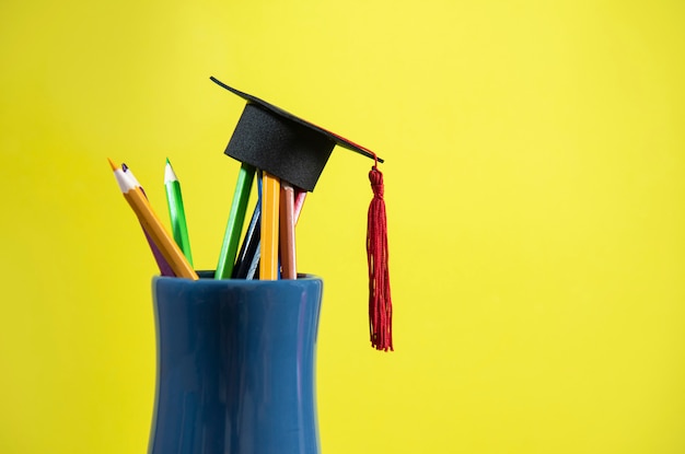 Education and back to school concept with graduation cap on pencils colour in a pencil case