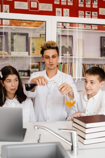 Education Chemical experiments at a chemistry lesson at school Children classmates hold test tubes and conduct experiments in the laboratory