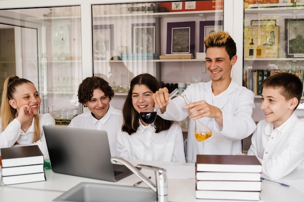 Education Chemical experiments at a chemistry lesson at school Children classmates hold test tubes and conduct experiments in the laboratory