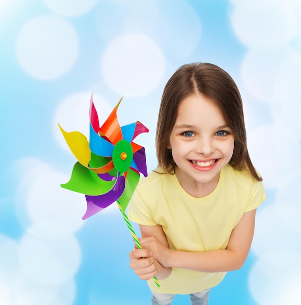 education, childhood and ecology concept - smiling child with colorful windmill toy