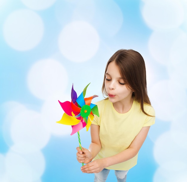 教育、子供時代、エコロジーの概念-カラフルな風車のおもちゃで笑顔の子供