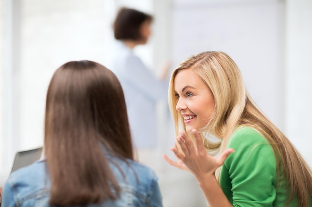 education concept - attractive student girl gossiping in lecture at school