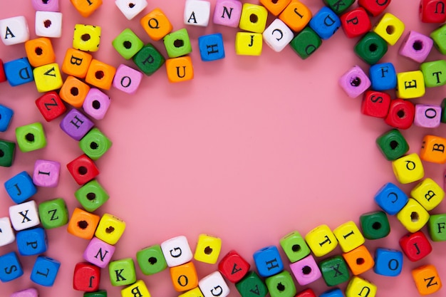 Concetto di educazione. blocchi colorati con lettere su sfondo rosa. copia spazio.