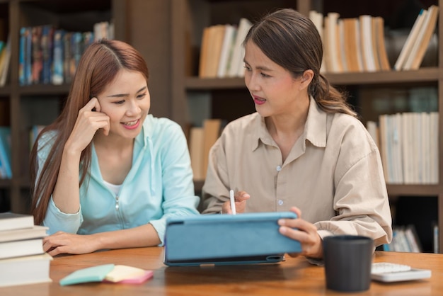 Education concept female tutor pointing math quiz on tablet and\
explaining math lesson to students