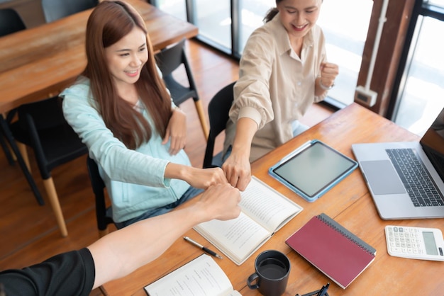 Education concept Female tutor and students making fist bump after successful tutoring lessons