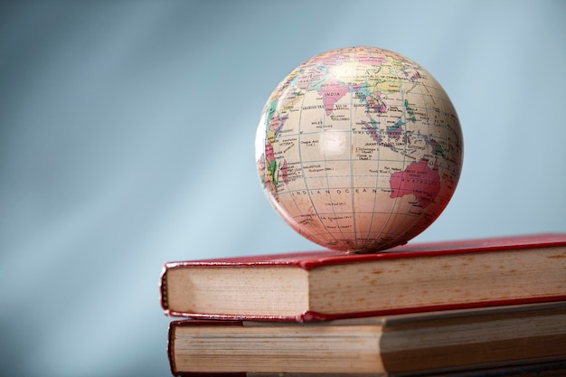 Education concept globe on top stack of books