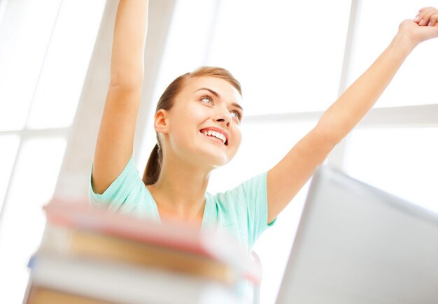 education concept - happy student girl with computer at school