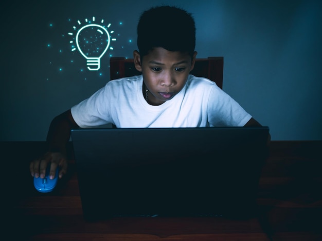 Education concept image creative idea and innovation boy
sitting staring at computer.