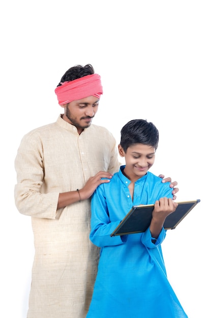 Education concept : indian farmer with his school boy on white background.