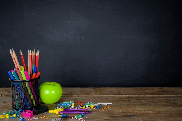 Education concept Stationery various types were placed on the table a chalkboard background with space to add text images prepared in advertising Green Apple is a component