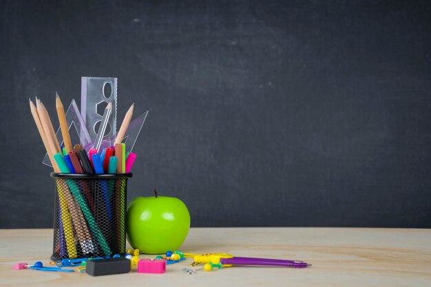 Education concept Stationery various types were placed on the table a chalkboard background with space to add text images prepared in advertising Green Apple is a component