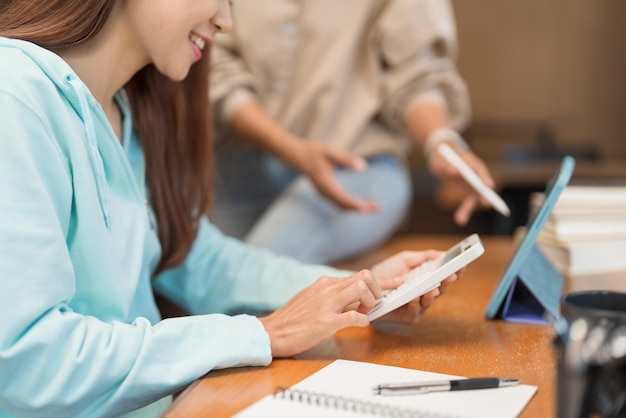 Education concept Teenage girl use calculator to doing math quiz while tutor explaining lesson